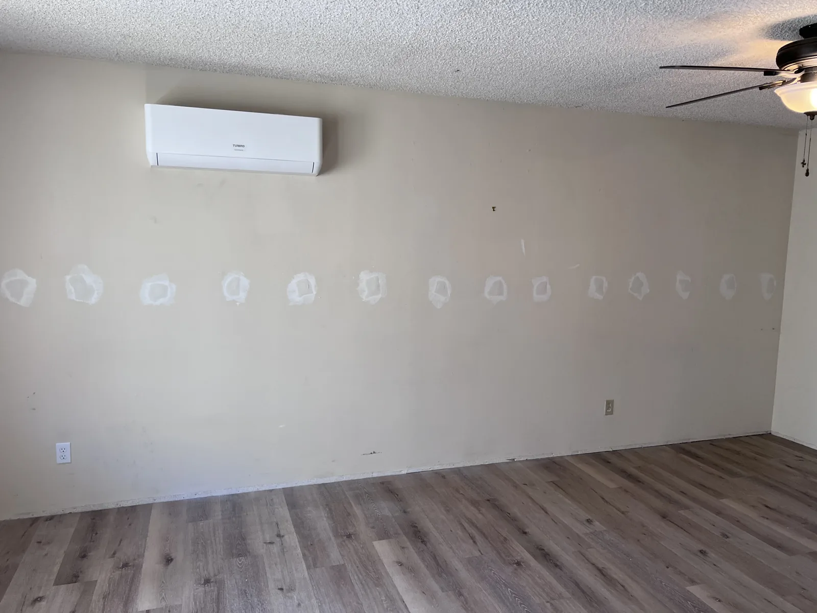 Wall with drill and fill holes patched after dense-pack insulation in Granada Hills